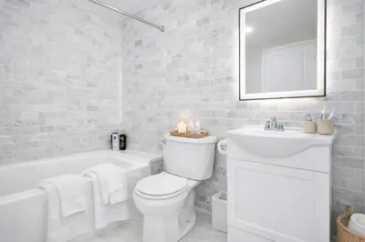 a white bathroom with a toilet and a sink at New Haven Staycation Near Yale Washer and Dryer Groups in New Haven