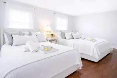 a white bedroom with two beds with white sheets at New Haven Staycation Near Yale Washer and Dryer Groups in New Haven