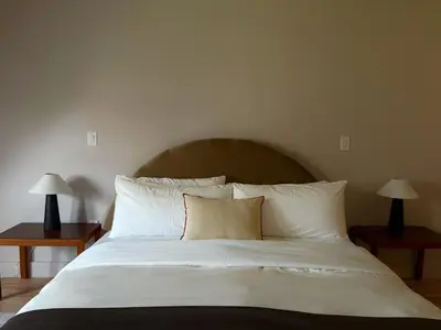 a bed with white sheets and two lamps on tables at 3.8 Million Dollar Brownstone Newly Renovated in New York