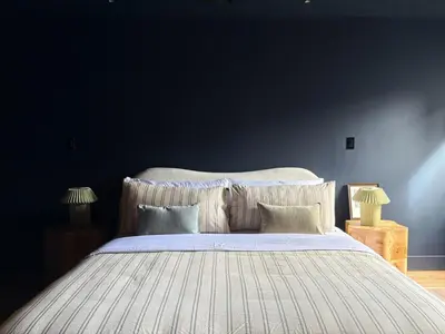 a bedroom with a large bed with a blue wall at 3.8 Million Dollar Brownstone Newly Renovated in New York