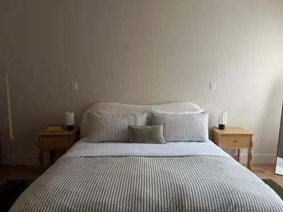 a bedroom with a bed with two nightstands and two lamps at 3.8 Million Dollar Brownstone Newly Renovated in New York