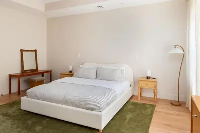 a white bedroom with a white bed and a mirror at 3.8 Million Dollar Brownstone Newly Renovated in New York
