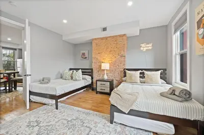 a bedroom with two beds and a dining room at Luxury and Chic 2BR 2BA Apt Mins to NYC and Hoboken in Jersey City