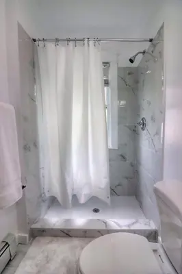 a white bathroom with a shower and a toilet at Cozy two bedroom home close to everything in Amsterdam