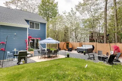 a backyard with a table and chairs and a grill at Azure on the Pocono in Tobyhanna