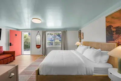 a bedroom with a large white bed and a couch at Ambler Hotel in Saratoga Springs