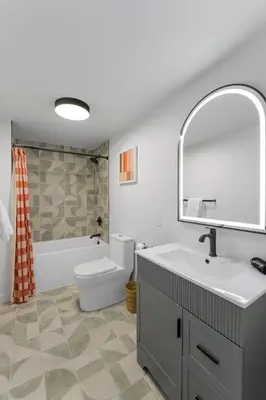 a bathroom with a sink and a toilet and a mirror at Ambler Hotel in Saratoga Springs