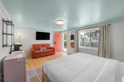 a bedroom with a bed and a red couch at Ambler Hotel in Saratoga Springs