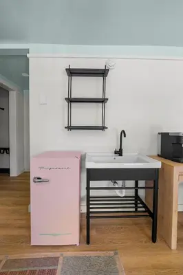 a kitchen with a white sink and a table at Ambler Hotel in Saratoga Springs