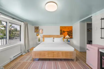 a bedroom with a bed and a large window at Ambler Hotel in Saratoga Springs