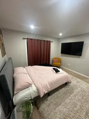 a bedroom with a bed and a flat screen tv at Cozy Rooftop Home, Near Downtown Newark, EWR & NYC in Newark