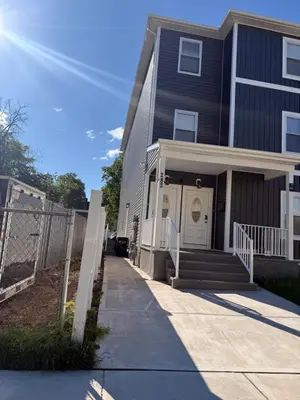 a black house with a fence and a sidewalk at Excel homes in East Orange