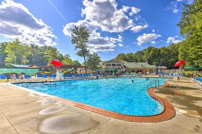 a large swimming pool at a resort with people in it at Less Than 2 Mi to Big Bass Lake Modern Mtn Chalet! in Gouldsboro