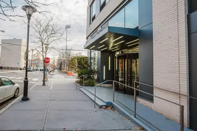 a building on a street with a stop sign at Blueground Jersey City EV charging nr park NYC-1690 in New York