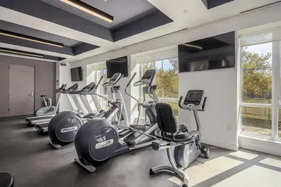 a gym with several cardio machines in a room at Blueground Jersey City EV charging nr park NYC-1690 in New York
