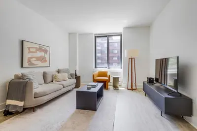 a living room with a couch and a tv at Blueground LIC pool wd nr Gantry Park NYC-1845 in New York
