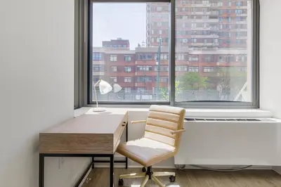 a desk with a chair in front of a window at Blueground LIC pool wd nr Gantry Park NYC-1845 in New York