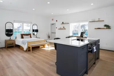 a room with a bed and a kitchen with a counter at Chic Studio Close to Harbor Point in Stamford