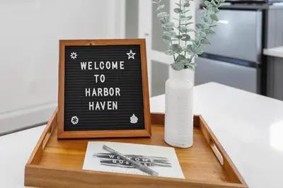 a wooden tray with a welcome to harborhaven sign and a vase at Chic Studio Close to Harbor Point in Stamford