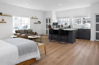 a bedroom with a bed and a kitchen and a living room at Chic Studio Close to Harbor Point in Stamford