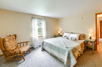 a bedroom with a bed and a chair and a window at Hike and Baseball Near Cooperstown Home on 30 Acres in Westford