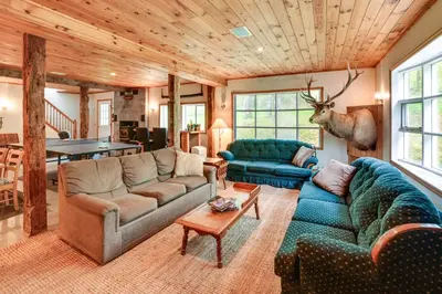 a living room with two couches and a table at Hike and Baseball Near Cooperstown Home on 30 Acres in Westford