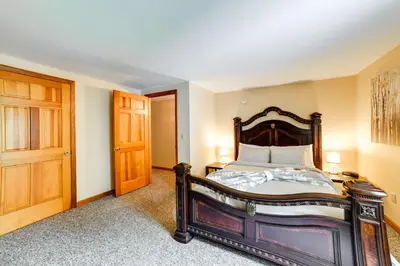 a bedroom with a bed and a wooden door at Hike and Baseball Near Cooperstown Home on 30 Acres in Westford
