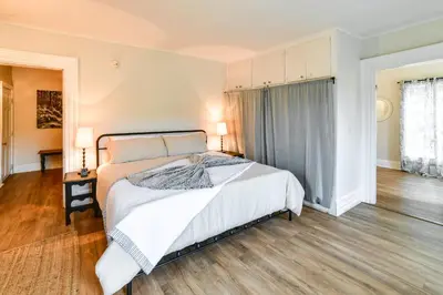 a bedroom with a large white bed and wooden floors at Hike and Baseball Near Cooperstown Home on 30 Acres in Westford