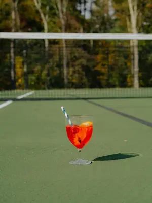 a drink in a wine glass on a tennis court at Prospect Berkshires in North Egremont