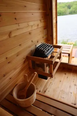 a cabin with a sauna with wooden floors and a tub at Prospect Berkshires in North Egremont