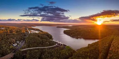 an aerial view of a river with the sun setting at Honesdale Escape ~ A Place to Remember - Apartment in Honesdale