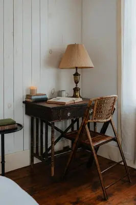 a wooden desk with a lamp and a chair at Book Village Inn - Dickinson Room Queen Bed in Hobart