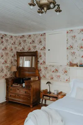 a bedroom with a bed and a dresser and a mirror at Book Village Inn - Twain Room Queen Bed in Hobart