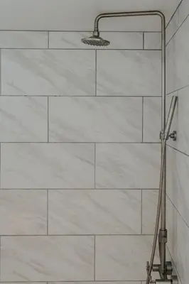 a shower in a bathroom with white marble walls at Book Village Inn - Twain Room Queen Bed in Hobart