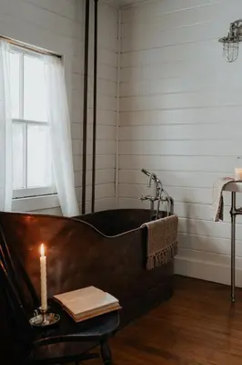 a black tub with a candle on a table at Book Village Inn - Twain Room Queen Bed in Hobart