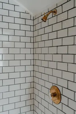 a white tiled bathroom with a toilet in it at Book Village Inn - Hemingway Room King Bed in Hobart