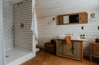 a bathroom with a tub and a sink and a shower at Book Village Inn - Hemingway Room King Bed in Hobart