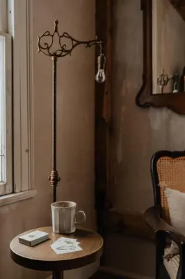 a table with a lamp and a coffee cup on it at Book Village Inn - Hemingway Room King Bed in Hobart