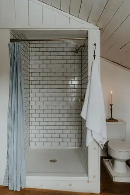 a bathroom with a shower and a toilet at Book Village Inn - Hemingway Room King Bed in Hobart