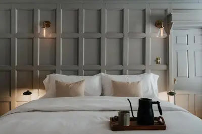 a bedroom with a large white bed with a headboard at Book Village Inn - Entire Hotel in Hobart