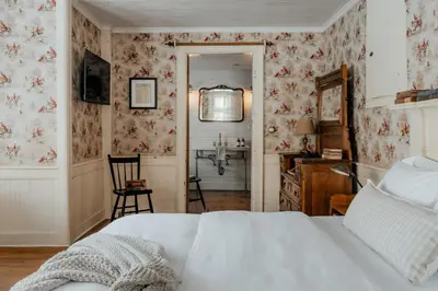 a bedroom with a bed and a bathroom with a sink at Book Village Inn - Entire Hotel in Hobart