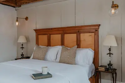 a bedroom with a white bed with a wooden headboard at Book Village Inn - Entire Hotel in Hobart