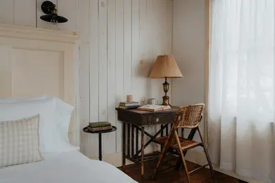 a bedroom with a bed and a desk with a lamp at Book Village Inn - Entire Hotel in Hobart