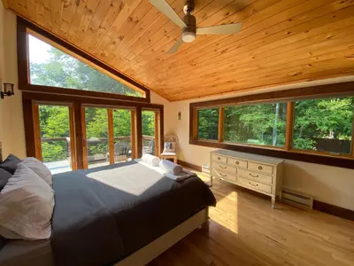 a bedroom with a large bed in a room with windows at Mountain Lodge Retreat, Near New Paltz & Hikes in New Paltz