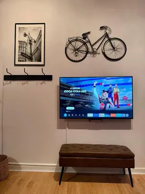 a flat screen tv hanging on a wall with a bike on it at Gotham House in New York