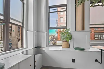 a room with a large window with a view of a city at CityNest Hotel in New York