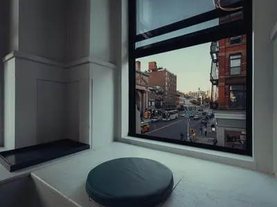 a pillow sitting on a window sill with a view of a street at CityNest Hotel in New York