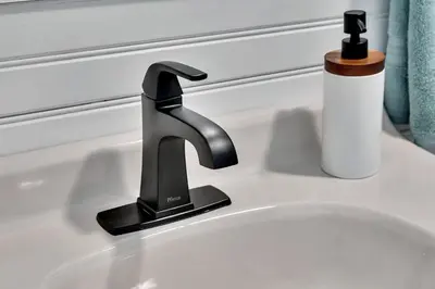 a black faucet on a white sink at Wooded lakefront chalet with hot tub and game room in South Kortright