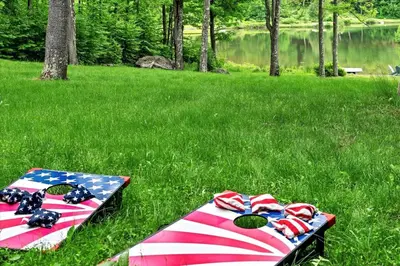 an american flag picnic set up in the grass at Wooded lakefront chalet with hot tub and game room in South Kortright