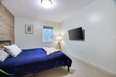 a bedroom with a bed and a tv on the wall at Apartment Minutes from Camelback Mountain with Washer Dryer in Tannersville